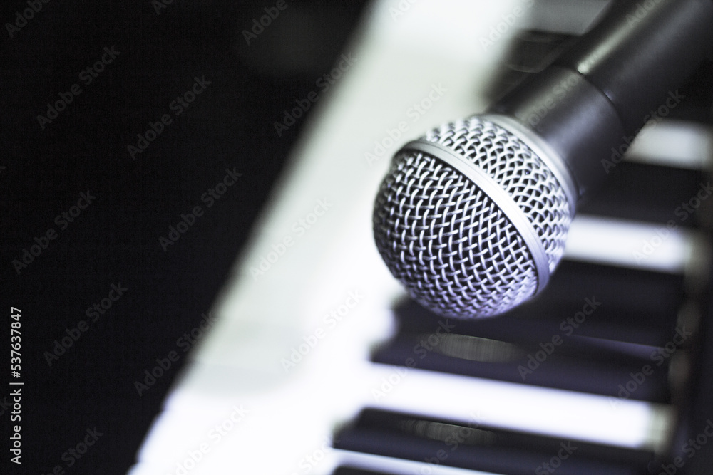 Microphone over piano keys in dim light Microphone over piano keys in dim light