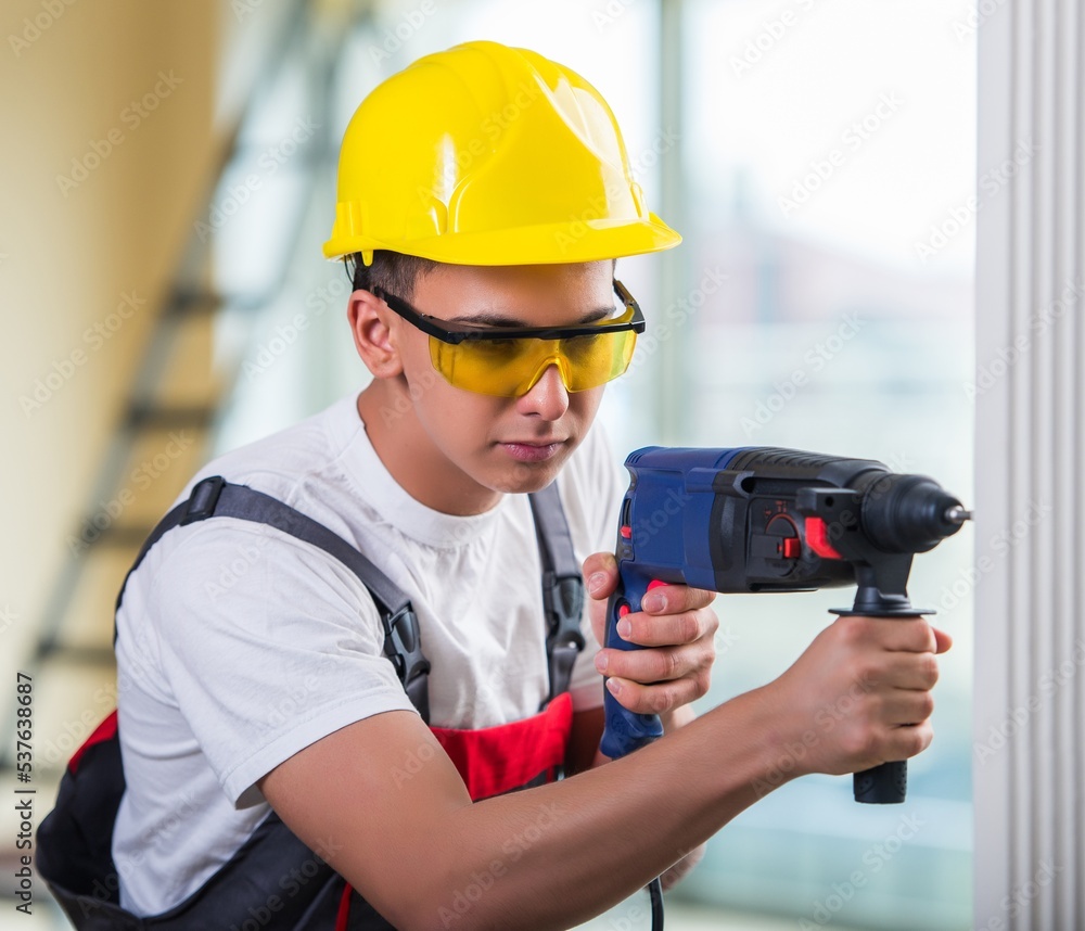 Man drilling the wall with drill perforator Man drilling the wall with drill perforator