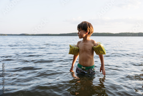 Wallpaper Mural A boy wearing inflatable armlets is standing in the water Torontodigital.ca