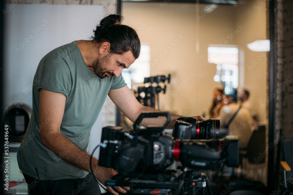 Director of photography with a camera in his hands on the set. Filming process indoors, studio Director of photography with a camera in his hands on the set. Filming process indoors, studio