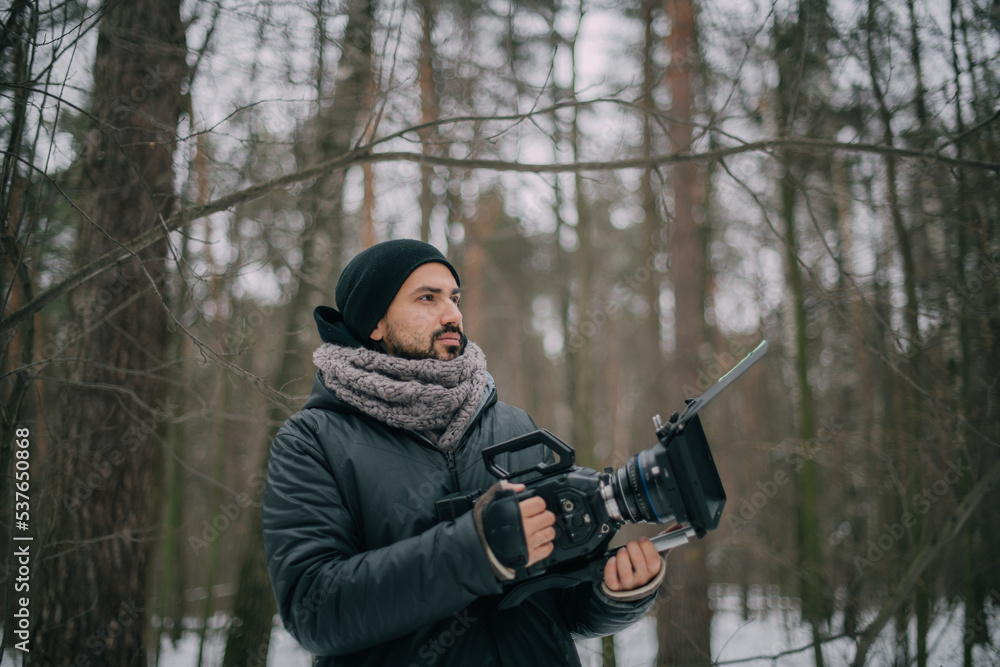 Director of photography with a camera in his hands on the set. Professional videographer at work on filming a movie, commercial or TV series Director of photography with a camera in his hands on the set. Professional videographer at work on filming a movie, commercial or TV series