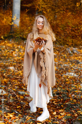 A fantastic woman walks through the autumn forest.