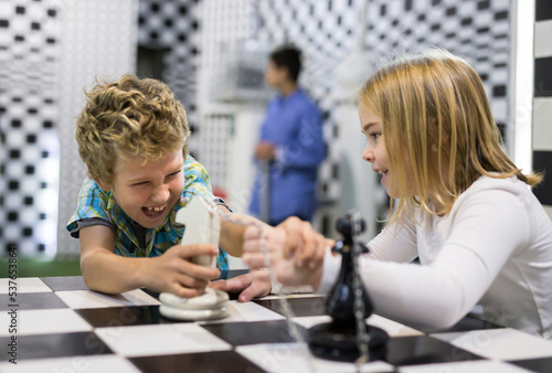 Curious boy and girl discuss the game in the chess quest room
