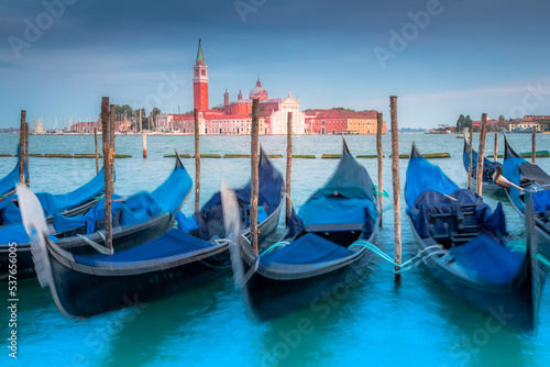 Gondole docked by wooden mooring poles in grand canal, Ethereal Venice, Italy © Aide