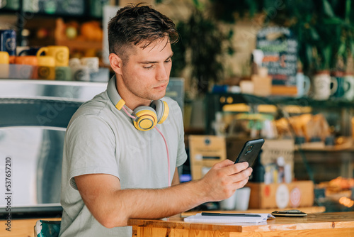 Stylish male studen sits at table in a cafe with pen and notebook photo