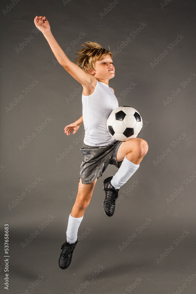 Young male soccer player jumps to trap the ball with his body