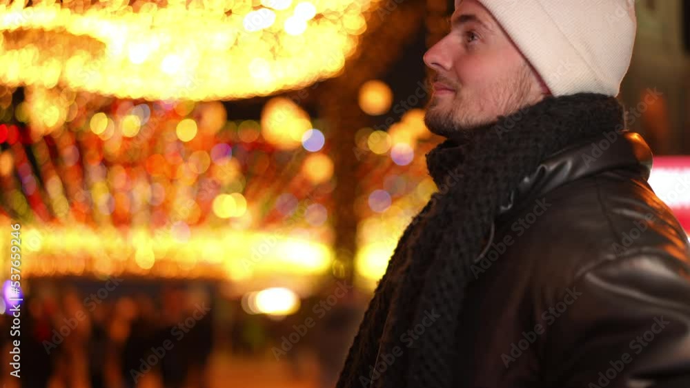 Side view worried handsome Caucasian man checking time on watch waiting outdoors on Christmas night in urban city. Anxious guy waiting on New Year's eve outdoors standing on the right Side view worried handsome Caucasian man checking time on watch waiting outdoors on Christmas night in urban city. Anxious guy waiting on New Year's eve outdoors standing on the right