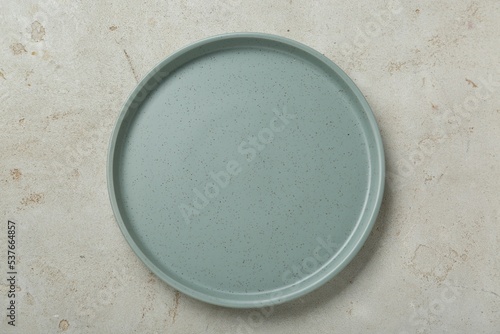Empty ceramic plate on light grey table, top view