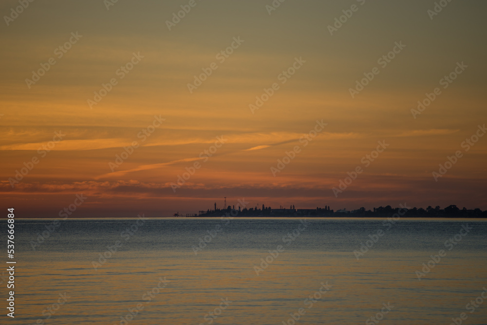 Seascape at sunset with the coastline of the city