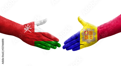 Handshake between Andorra and Oman flags painted on hands, isolated transparent image.