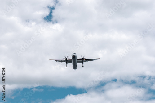 Small propeller plane flying above the head before landing. Bottom of the plane on the sky