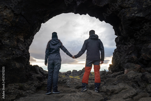 loving couple holding hands inside a cave