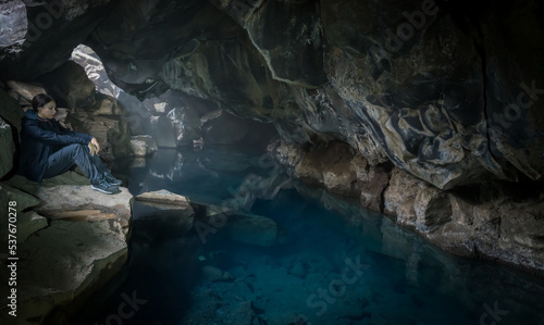 woman pensive inside the cave illuminated