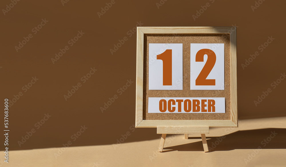 October 12th. Day 12 of month, Calendar date. Cork board, easel in sunlight on desktop. Close-up, brown background. Autumn month, day of year concept October 12th. Day 12 of month, Calendar date. Cork board, easel in sunlight on desktop. Close-up, brown background. Autumn month, day of year concept