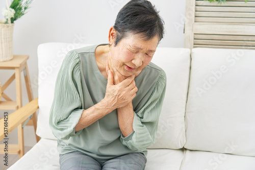 リビングで喉が詰まる高齢者女性 © siro46