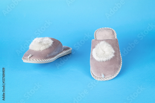 Front view of walking slippers on a blue background.