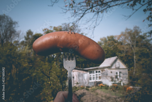 Selective focus. Sausage on a fork. Farm.