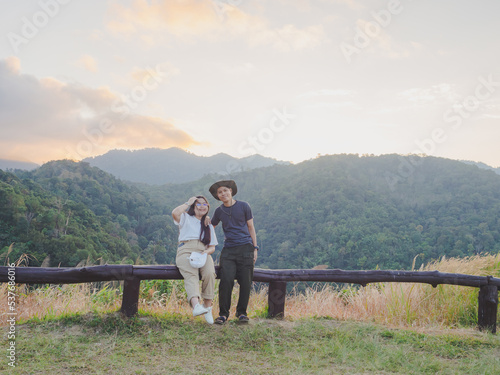 Happy young couple watching the sunset in the mountains at Mae Wong National Park, Kamphaeng Phet, Thailand © TongTa
