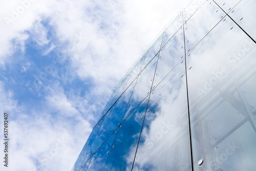 modern glass office building reflecting cloudy sky. contemporary urban architecture.