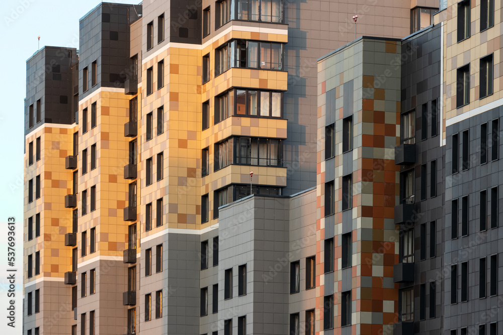 Fragment of multicolored facade of panel building with protruding architectural parts at sunset. Exterior architecture. Aerial view.