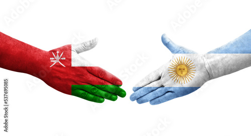 Handshake between Argentina and Oman flags painted on hands  isolated transparent image.