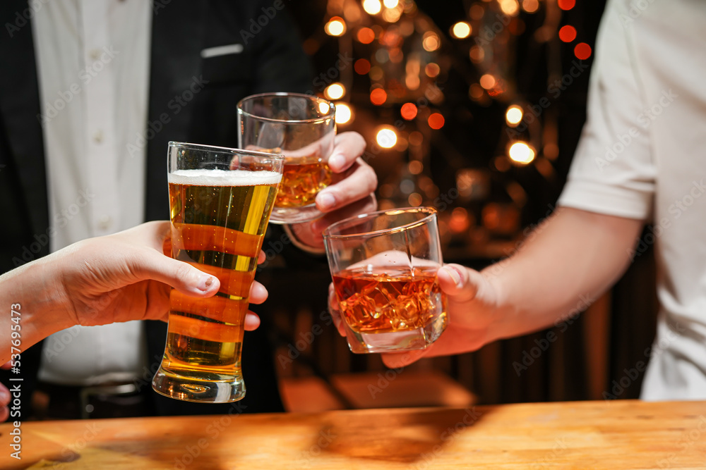 food and drink male friends are happy drinking beer and clinking glasses at a bar or pub. food and drink male friends are happy drinking beer and clinking glasses at a bar or pub.