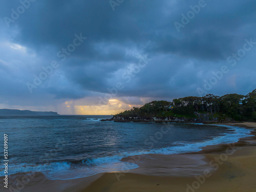 Sunrise seascape with overcast sky and rain clouds
