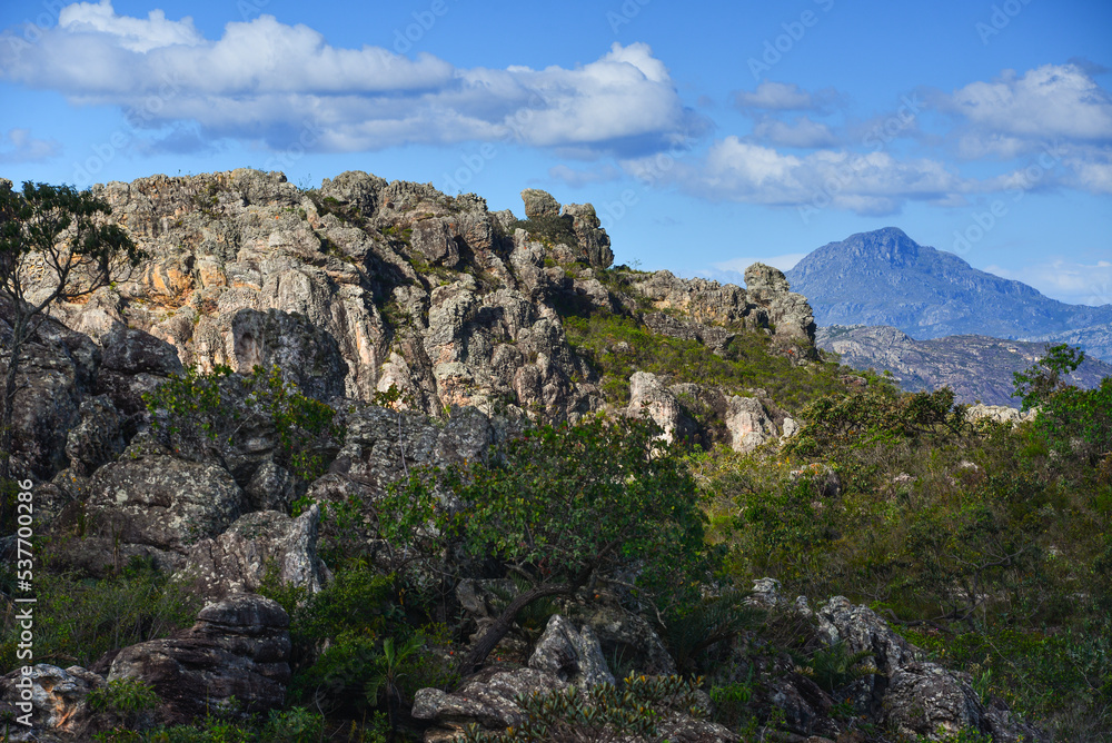 Rugged rock formations and the Pico do Itambé mountain (2.002m), one of the highest on the Serra do Espinhaço range, as seen from the road between Milho Verde and Diamantina, Minas Gerais, Brazil