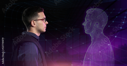 Young man with his digital projection on dark background. Concept of digital twin photo