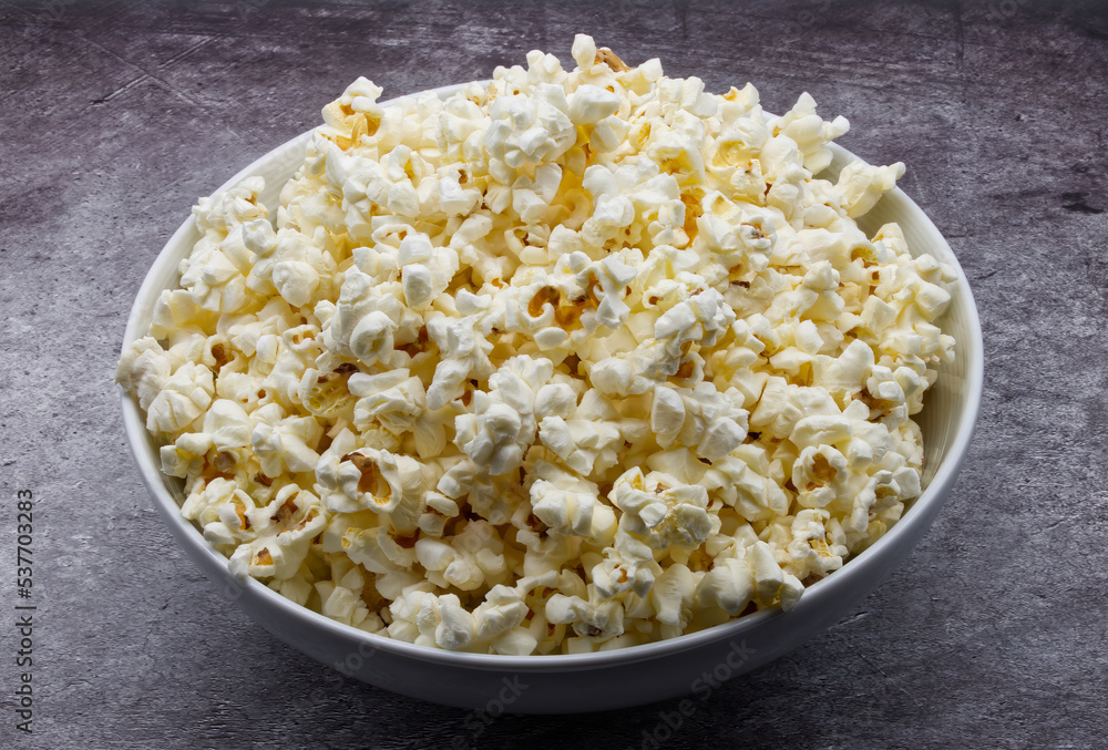 Bowl of fresh popcorn isolated on grey concrete background. Bowl of fresh popcorn isolated on grey concrete background.