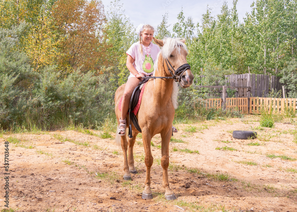 Outside on a beautiful warm day, a girl rides a horse. Outside on a beautiful warm day, a girl rides a horse.