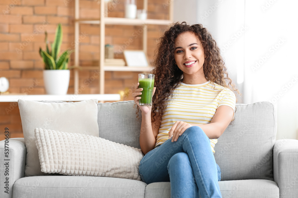 Young African-American woman with healthy smoothie at home Young African-American woman with healthy smoothie at home