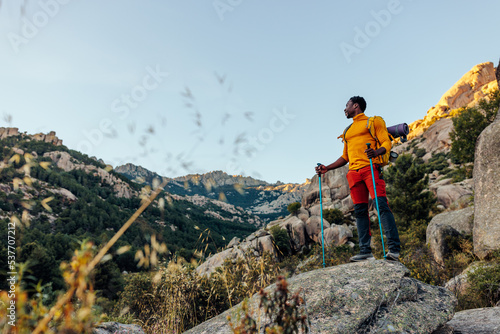 Mountain hiker standing in rocky terrain.