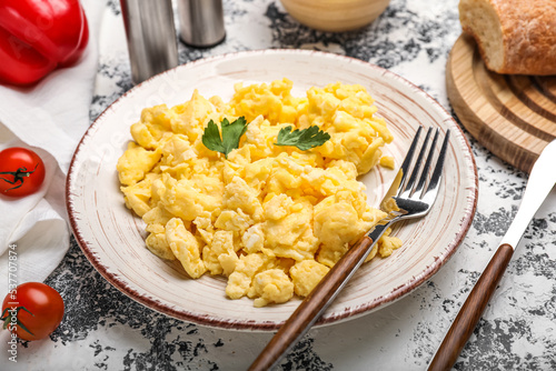 Plate of tasty scrambled eggs on grunge background, closeup