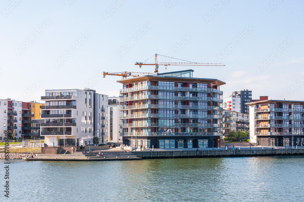 Residential area by the water with construction cranes