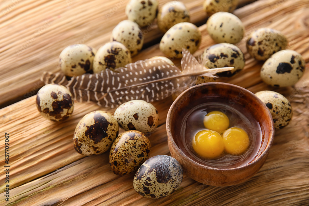 Bowl of cracked and whole quail eggs on wooden table, closeup Bowl of cracked and whole quail eggs on wooden table, closeup