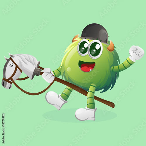 Cute green monster playing with toy horse