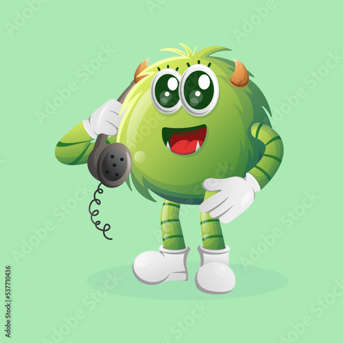 Cute green monster pick up the phone, answering phone calls