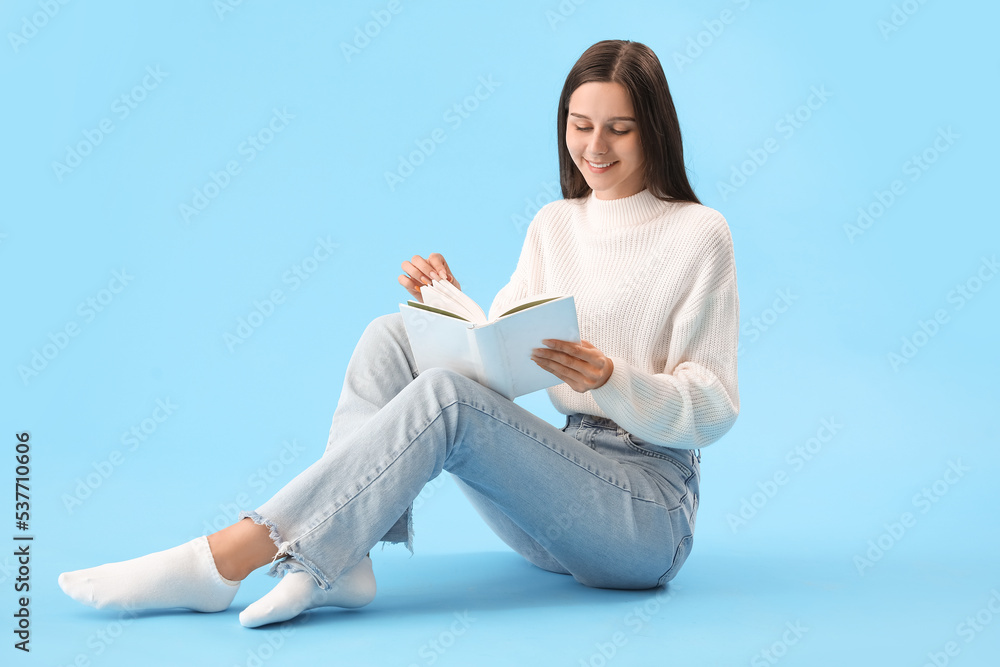 Beautiful woman reading book on blue background Beautiful woman reading book on blue background