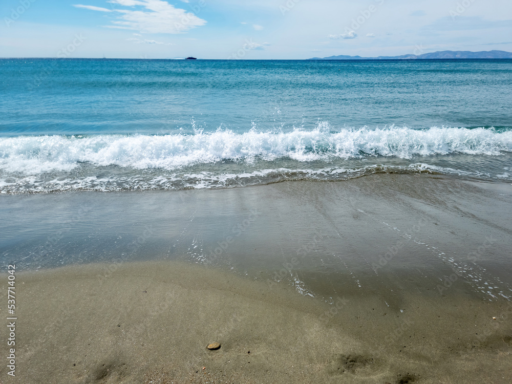 Sea water white foam on wet sand. Empty sandy beach, Greek island Cyclades, Greece. Space Sea water white foam on wet sand. Empty sandy beach, Greek island Cyclades, Greece. Space