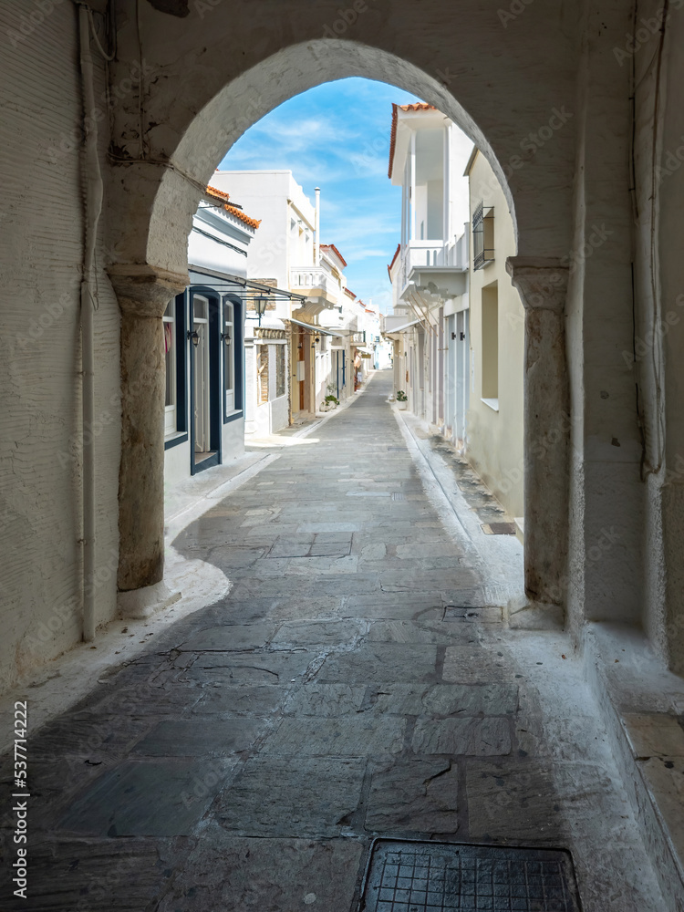 Greece, Andros island, Cyclades. View from arched cover stonewall of houses at Chora town. Vertical