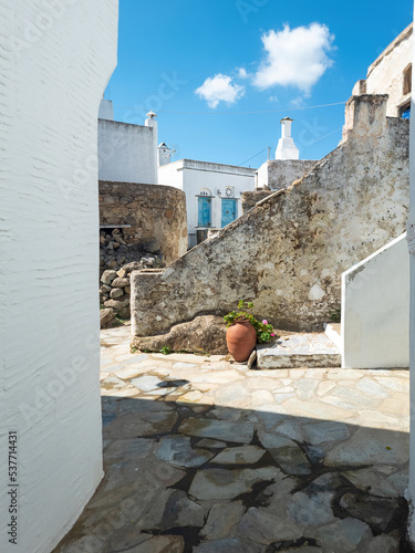 Greece Cyclades, Tinos island Volax village. Old stonewalls between whitewashed buildings. Vertical photo