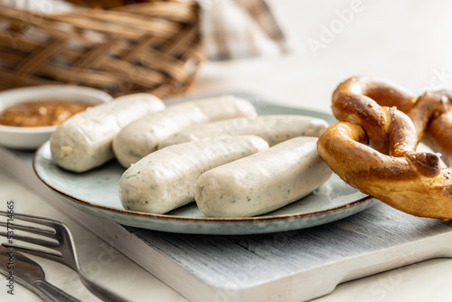 Traditional Bavarian white sausages on plate and pretzes.