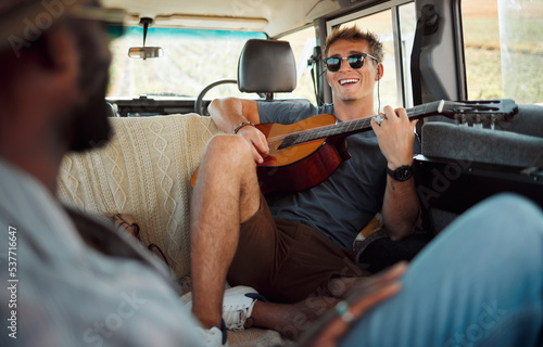 Fototapeta Naklejka Na Ścianę i Meble -  Man with guitar, music in van and smile on travel vacation road trip together with friends. Group holiday in summer, relax and happy musician singing with instrument on a countryside safari adventure