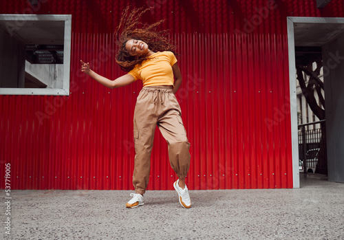 City, hip hop dance and an urban black woman in streetwear dancing outside in Sao Paulo. Music, dancer and a cool happy latino girl with outdoor street style, fun energy, freedom and youth in Brazil.