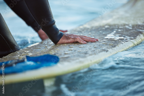 Surf, ocean surfing and hand of man on surfboard in sea water. Summer water sport fitness, male healthy lifestyle and outdoor wellness exercise and relax beach travel vacation in Hawaii