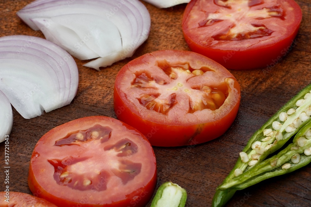 Healthy organic vegetables of Onion, Tomato, Chili cuts into pieces for cooking in the kitchen. Natural ingredient for lunch preparation in restaurant. Healthy organic vegetables of Onion, Tomato, Chili cuts into pieces for cooking in the kitchen. Natural ingredient for lunch preparation in restaurant.