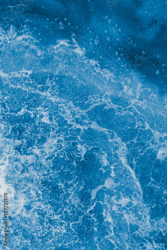 Dark blue sea surface with waves, splash