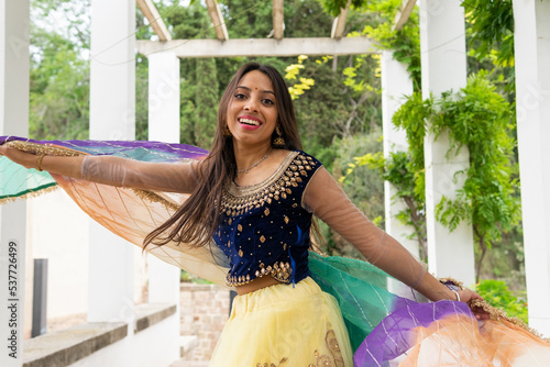 Cheerful Indian woman dancing in garden photo