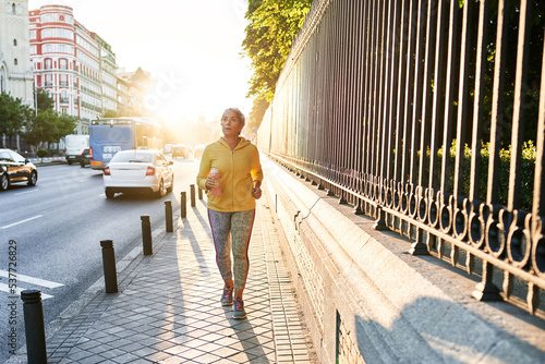 Elderly female athlete running on street photo
